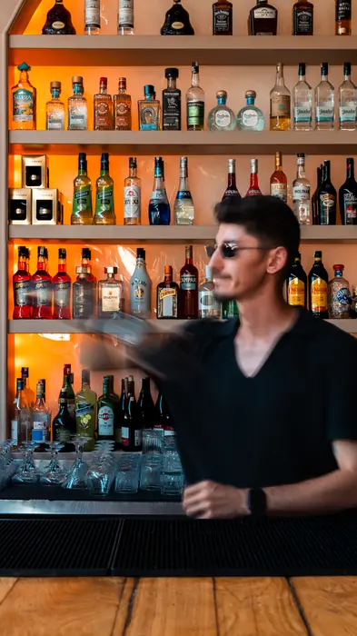 Bar rafları önünde barmen